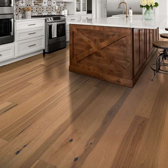 Warm-toned hardwood flooring in a modern kitchen with a wooden island | All Floors Design Centre