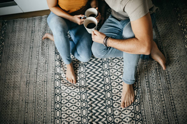Couple sitting together on a patterned area rug | All Floors Design Centre