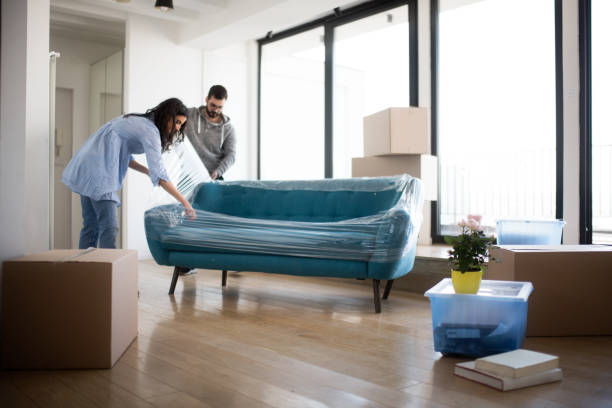 Couple moving furniture into a bright rental home with wood flooring | All Floors Design Centre